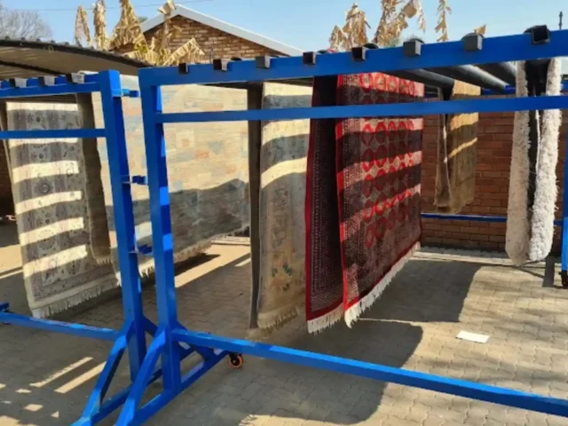 Rugs drying on a rack after professional cleaning